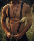 Festival-inspired black leather suspenders with adjustable straps and brass hardware by Bijou by Juju