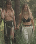 Juju, Founder of Bijou by Juju, and another woman are walking in a field wearing Bijou by Juju leather fringe belts